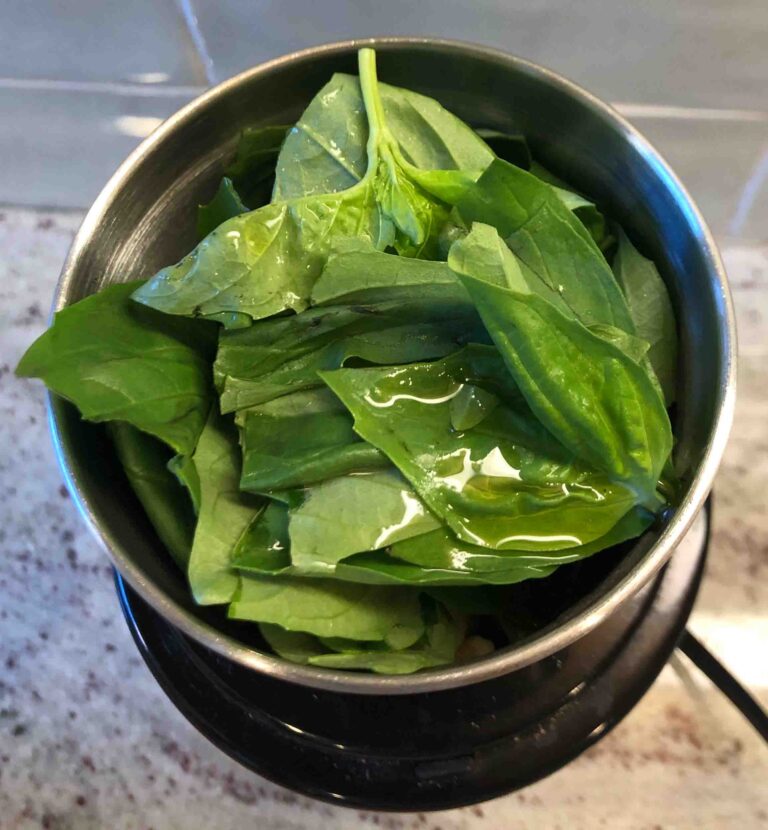 basil leaves and olive oil in spice grinder